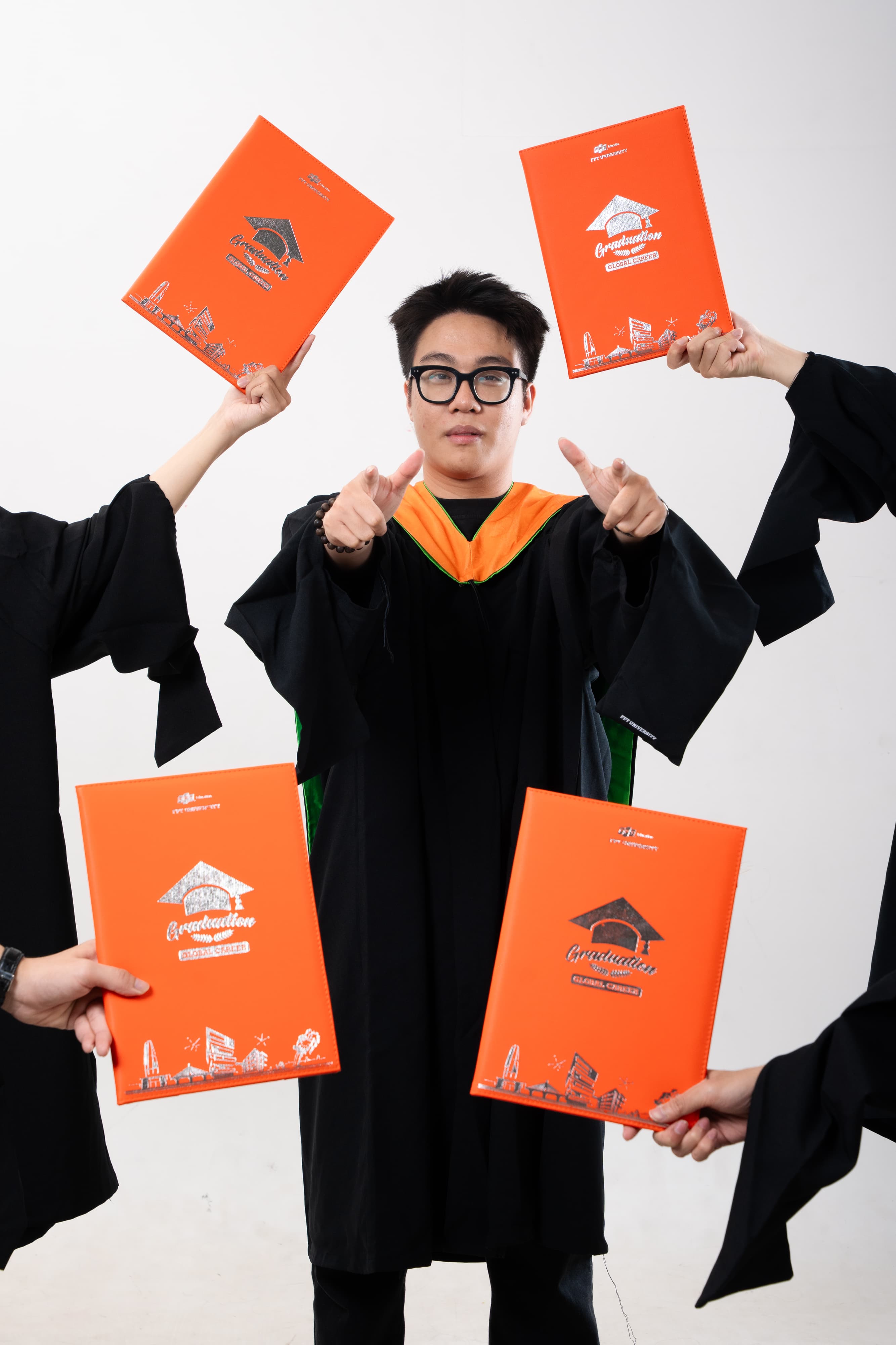 Five graduates posing together among auditorium seats